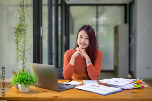 Businesswoman working attentively in front of laptop.Document review, analysis, and planning © Wasana