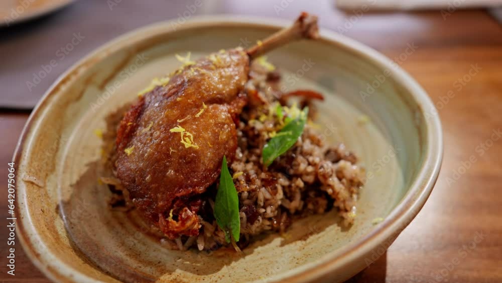 duck confit served with aromatic rice. The tender, flavorful duck and fragrant rice blend harmoniously, offering a sophisticated dish that epitomizes gourmet delight. High quality 4k footage duck confit served with aromatic rice. The tender, flavorful duck and fragrant rice blend harmoniously, offering a sophisticated dish that epitomizes gourmet delight. High quality 4k footage