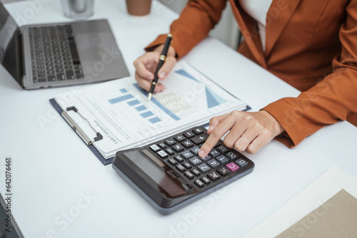 Close up hands of woman in brown formal suit checking bills  taxes  bank account balance  using calculator  Personal Checking  Empower Checking  Personal Savings  Certificates  IRAs  Money Market
