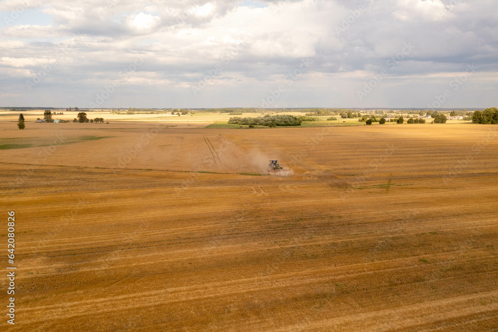 Fototapeta premium Drone photography of a farmer cultivating land with a tractor