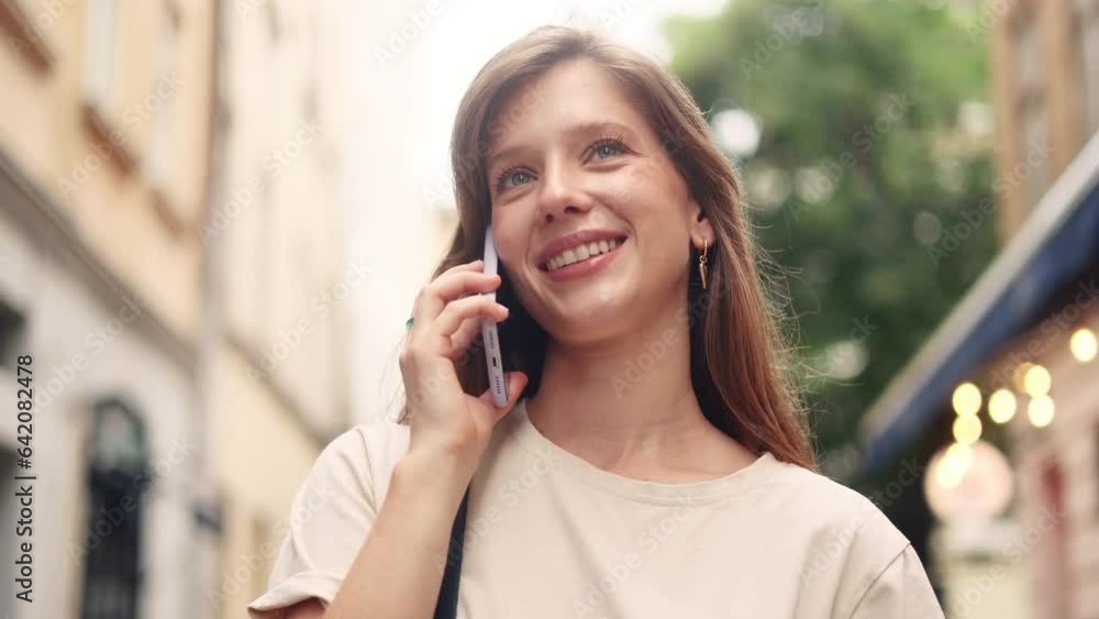 Portrait of young pretty woman having phone call working or personal conversation on smartphone at city street Happy smiling female talking by mobile phone outdoors Portrait of young pretty woman having phone call working or personal conversation on smartphone at city street Happy smiling female talking by mobile phone outdoors
