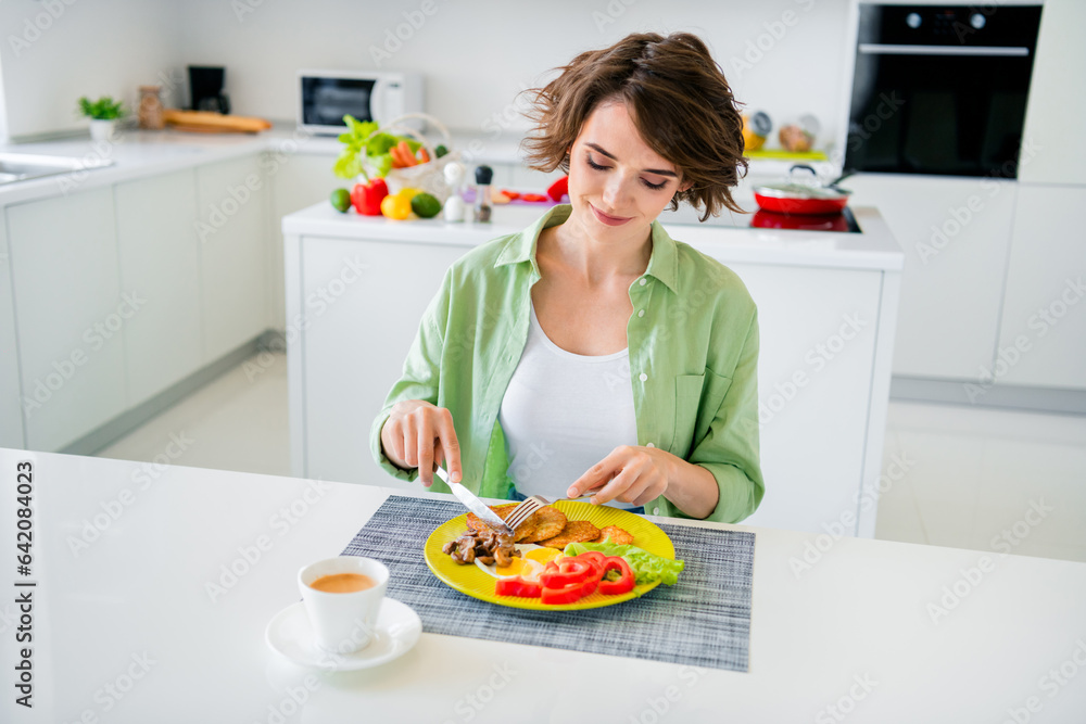 Photo of sweet shiny lady dressed green shirt smiling enjoying fresh cooked meal indoors house kitchen Photo of sweet shiny lady dressed green shirt smiling enjoying fresh cooked meal indoors house kitchen