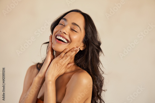 Beautiful laughing woman touching her skin with joy photo