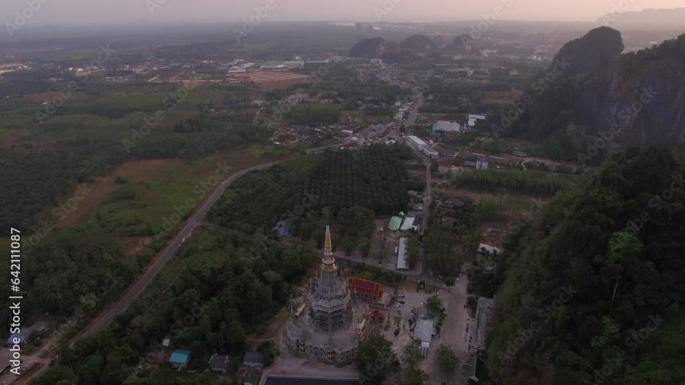 Aerial view is amazing sky at sunset behine The golden buddha on the top of high mountain. .It is more interesting temple complexes in Krabi Thailand, .as the monks live and worship Aerial view is amazing sky at sunset behine The golden buddha on the top of high mountain. .It is more interesting temple complexes in Krabi Thailand, .as the monks live and worship