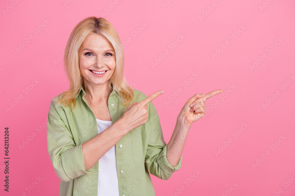 Photo of positive senior woman manager wear stylish khaki clothes recommend buy low price collection isolated on pink color background Photo of positive senior woman manager wear stylish khaki clothes recommend buy low price collection isolated on pink color background