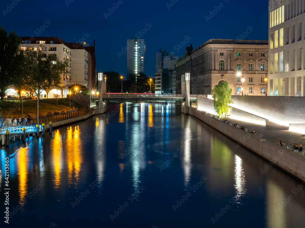 View of Berlin city river at dusk. Light trails along the river from evening lanterns.