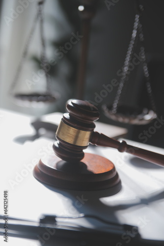 Business and lawyers discussing contract papers with brass scale on desk in office. Law, legal services, advice, justice and law concept picture with film grain effect