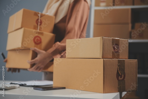 Starting small businesses SME owners female entrepreneurs Write the address on receipt box and check online orders to prepare to pack the boxes, sell to customers, sme business ideas online. © Phanphen