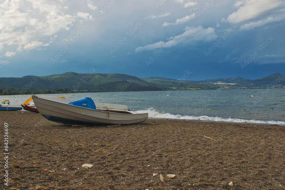 boat on the beach in Italy with mountains in background