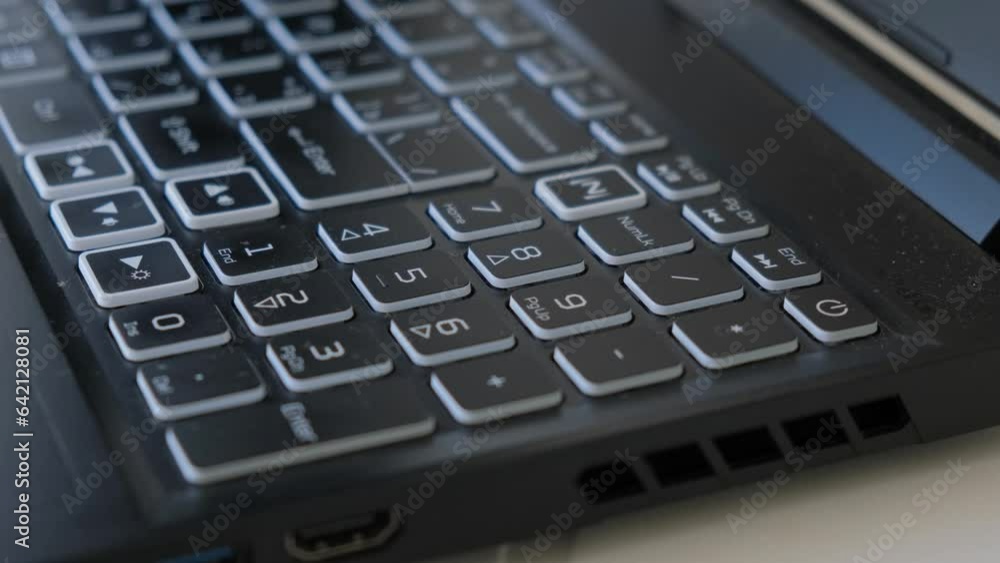 Close-up vacuum cleaner cleaning the keyboard on a laptop Close-up vacuum cleaner cleaning the keyboard on a laptop