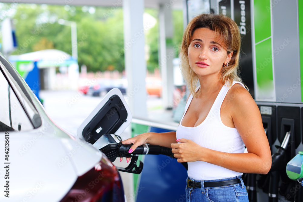 Woman refueling car at self service gas station Woman refueling car at self service gas station