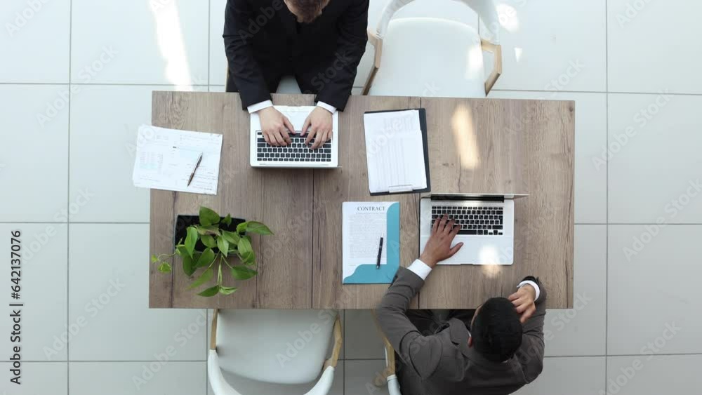 Confident business people talking and using computer in modern office Confident business people talking and using computer in modern office