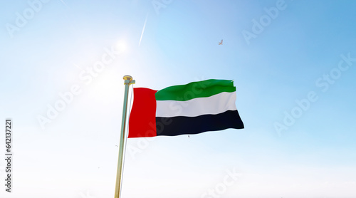 Canvas Print Flag of United Arab Emirates flag waving in the wind, sky and sun background