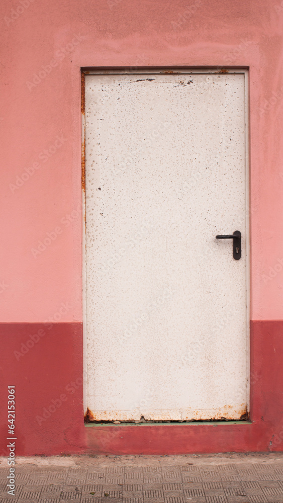 Puerta industrial blanca en pared rosa y roja Puerta industrial blanca en pared rosa y roja