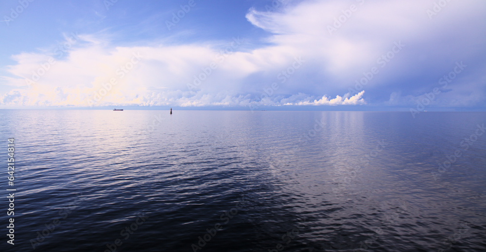 Clouds over Baltic sea with a blurred reflection in the water Clouds over Baltic sea with a blurred reflection in the water
