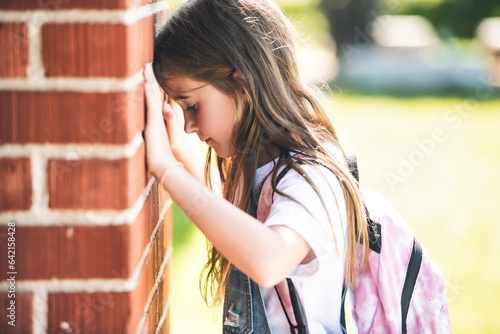 student girl wearing school backpack outside of the school have bad day