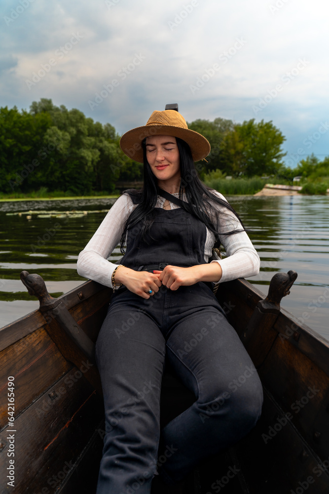 A brunette girl in a boat on the lake rest with mindfulness A brunette girl in a boat on the lake rest with mindfulness