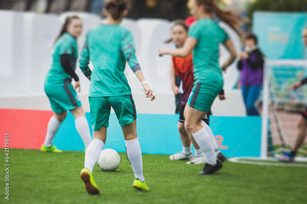 Female football street match outdoor game on an artificial astroturf lawn, girls play soccer game on a pitch field, young women participate in football competition on a stadium with green grass Female football street match outdoor game on an artificial astroturf lawn, girls play soccer game on a pitch field, young women participate in football competition on a stadium with green grass