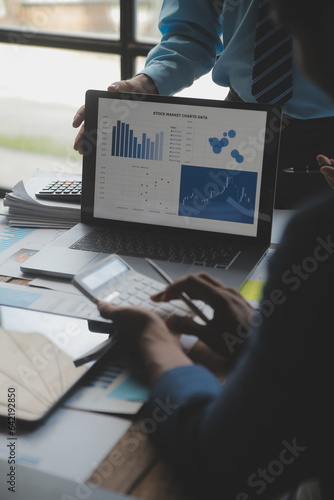 Financial analysts analyze business financial reports on a digital tablet planning investment project during a discussion at a meeting of corporate showing the results of their successful teamwork.