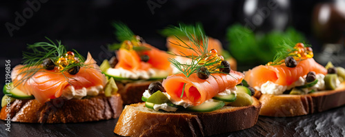 Fresh canapes topped with cheese, smoked salmon on bread. photo