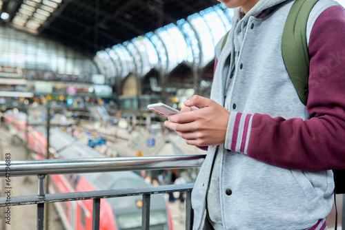Close-up of smartphone in hands of guy at railway station