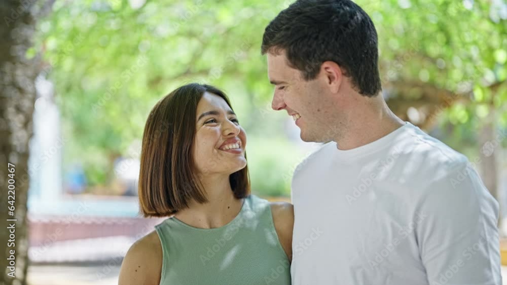 Beautiful couple hugging each other with serious face at park Beautiful couple hugging each other with serious face at park