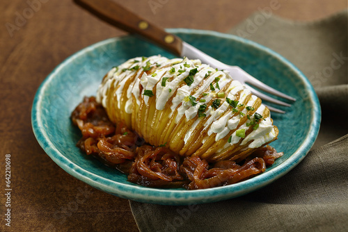 Deliciosa Batata cortada fininha assada no forno coberta com coalhada e cebola caramelizada photo