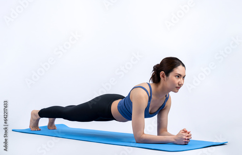 Fit young asian woman planing on exercising mat. Healthy lifestyle workout training routine on isolated background. Balance and endurance exercising concept. Vigorous