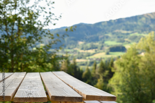 wooden picnic table for outdoor eating with a view of landscape from a garden