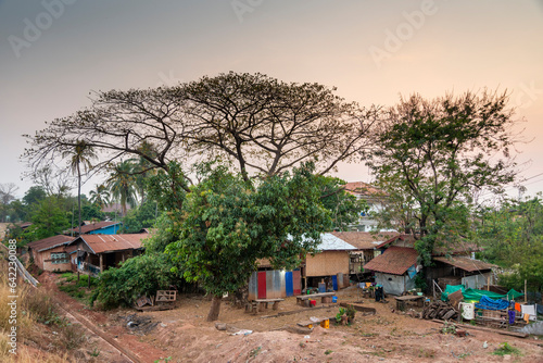 Simple,poor rural housing,amongst trees near to the Mekong river,Pakse,Southern Laos. © Neil