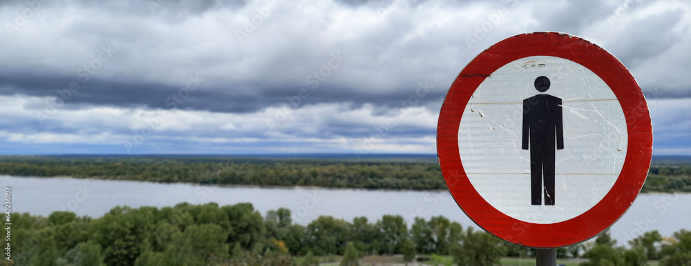 Restricted area Banner. No pedestrians road sign. Pedestrians prohibited. Restriction of freedom and movement. Forbidding symbol on background of cloudy landscape. Header for website, article, news.
