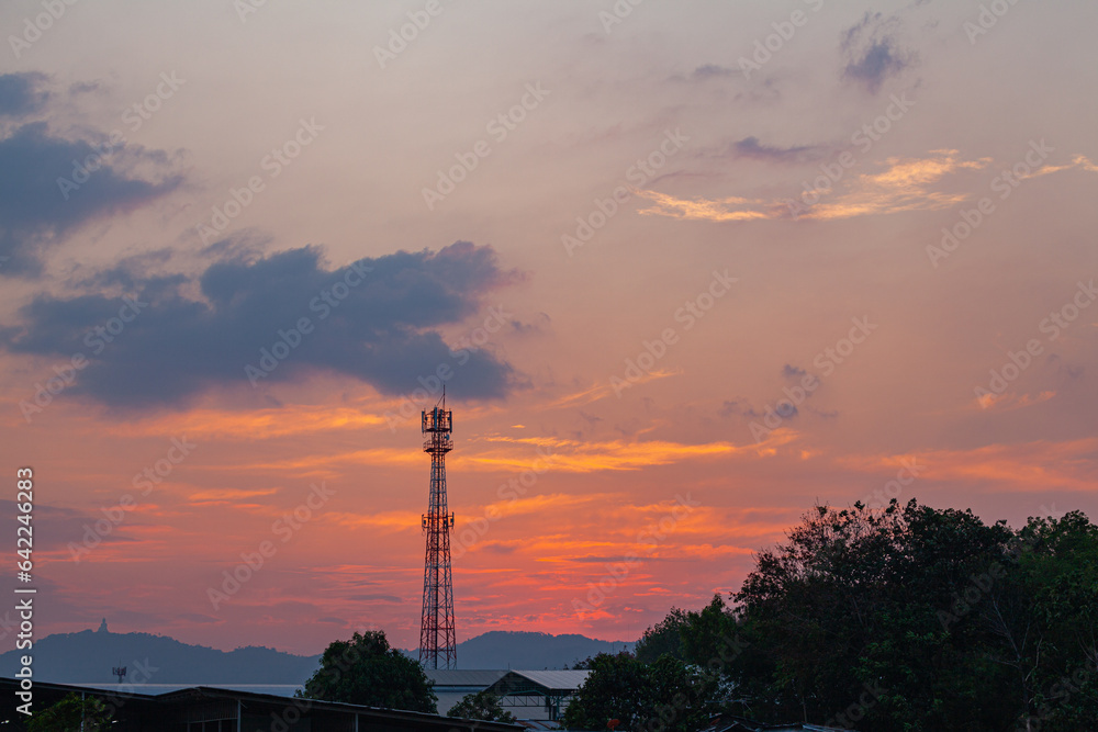 Obraz premium Amazing sky at sunset. Gradient color. Sky texture, abstract nature background..Sunset with red color light rays and other atmospheric effects..Big sunset and sweet lighting sky. phone antenna post.
