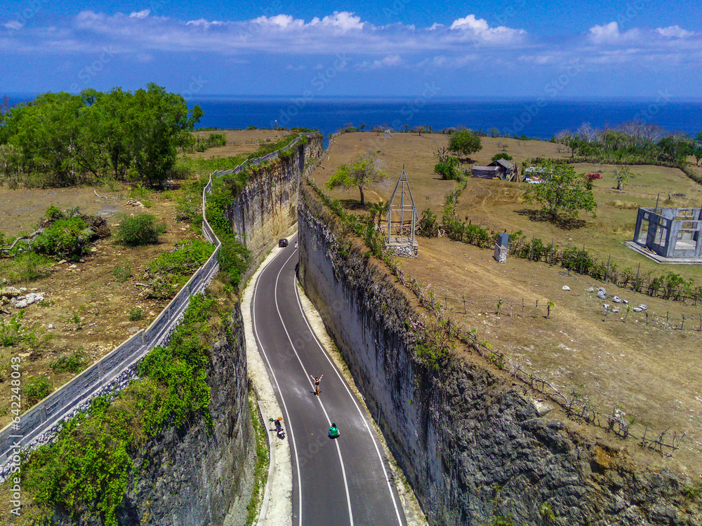 A high angle drone photo of the road between cliffs at Pandawa Beach in Bali offers a breathtaking perspective of this scenic coastal route.