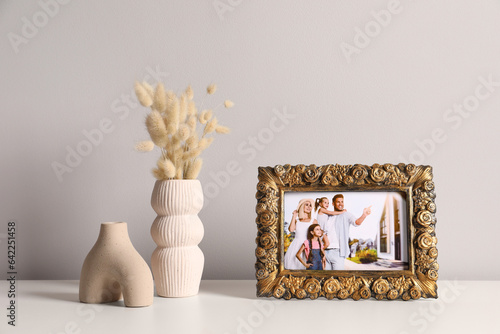Vintage square frame with family photo and other decor elements on white table