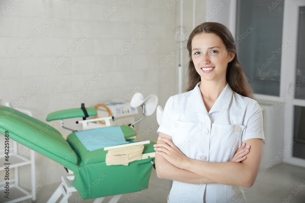 Portrait of smiling young gynecologist at workplace in clinic. Space for text Portrait of smiling young gynecologist at workplace in clinic. Space for text