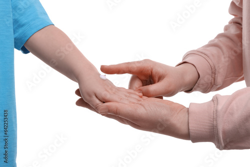 Mother applying ointment onto her son s hand on white background  closeup