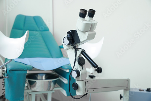 Modern binocular colposcope and gynecological chair in clinic photo