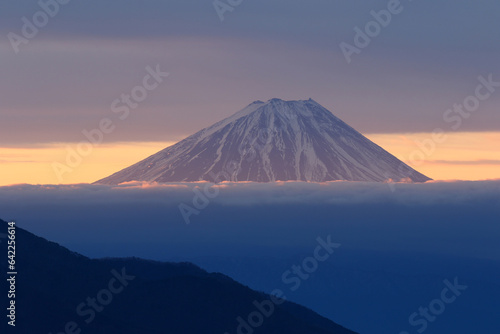 一条の朝日が差し込む雲海に浮かぶ夜明けの富士