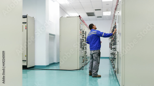 As an engineer fixes the automatic control switchboard to ensure safe operation, observe the essence of industrial technology. enhance platform visibility for microstock.  © supakitmod