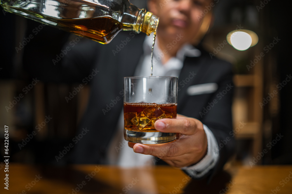 © aekachai - Barman pouring whiskey whiskey glass beautiful night