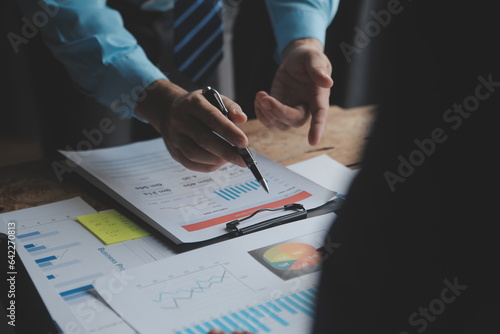 Financial analysts analyze business financial reports on a digital tablet planning investment project during a discussion at a meeting of corporate showing the results of their successful teamwork.