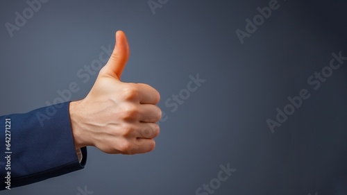 White-skinned hand in Jacket thumbs-up on a dark grey background