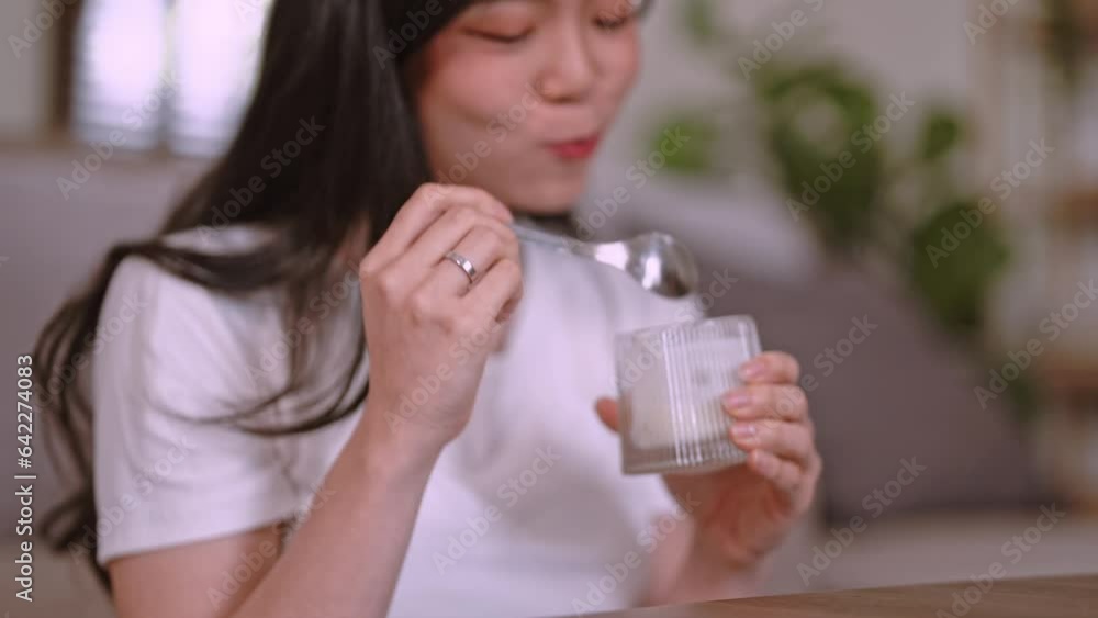 Beautiful of Asian woman eating yogurt, dairy product for breakfast at home, Healthy lifestyle concept.