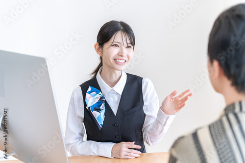 Plakat 男性と話をする制服を着た日本人女性