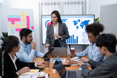 Young asian businesswoman presenting data analysis dashboard on TV screen in modern meeting. Business presentation with group of business people in conference room. Concord