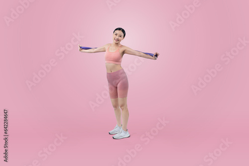 Vigorous energetic woman in sportswear portrait stretching resistance sport band. Young athletic asian woman strength and endurance training session workout routine concept on isolated background.