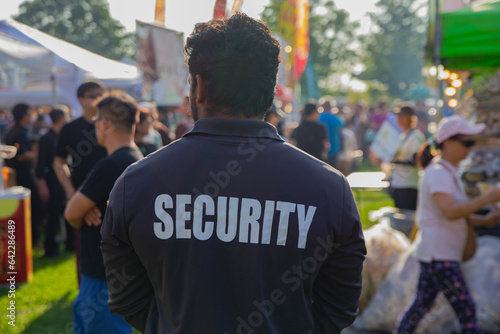A security guard is controlling the traffic and parking situation at an Asian festival in Canada.
