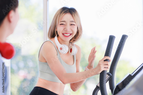 Asian young fit male female athlete jogger runner in sportswear sport bra legging wear wireless headphones smiling while exercise training on treadmill machine