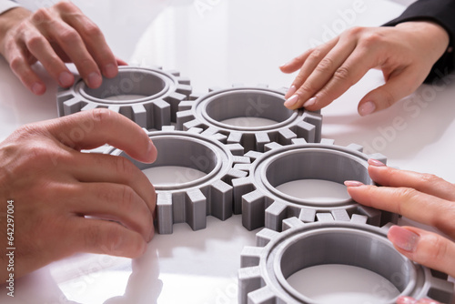 Fotografie Businesspeople Joining Gears On Desk