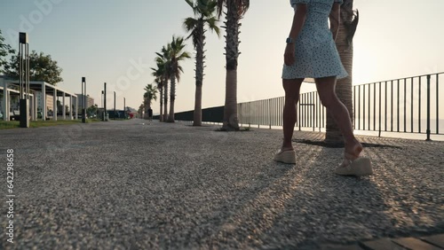 Sexy legs with high beige heels goes down the stairs of big city. Roamntic woman walking on boulvard alone. Attractive girl in short dress at summer season. Slow motion. High quality 4k footage photo